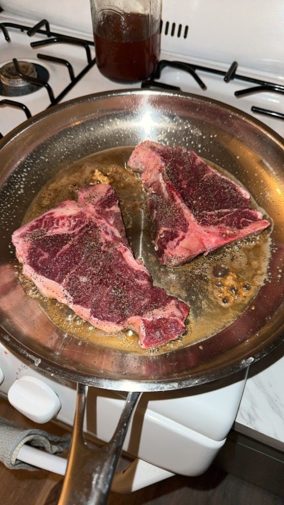 Steak cooking in a pan